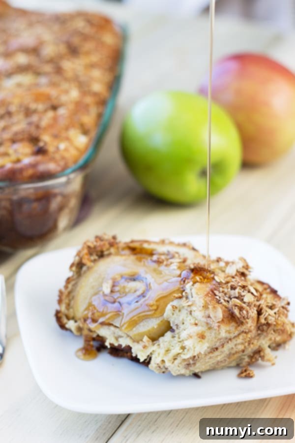 Overnight Apple Cinnamon French Toast Bake 5 a serving of apple french toast on a white plate with syrup drizzling over the top