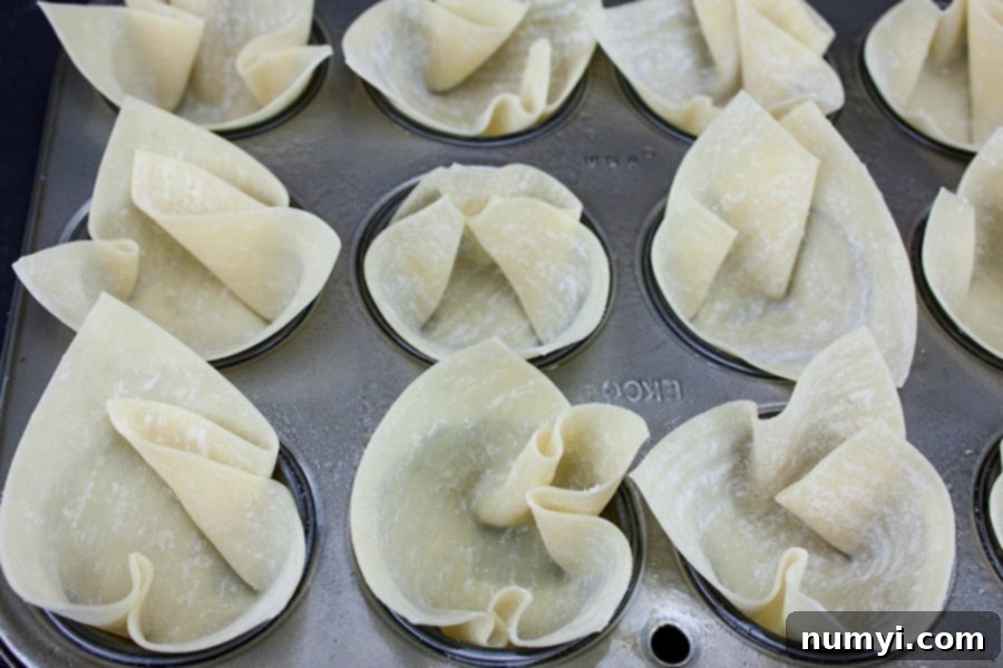 Creamy Spinach Artichoke Bites 4 Spinach Artichoke Cups - wontons placed in a mini muffin pan, ready for filling.