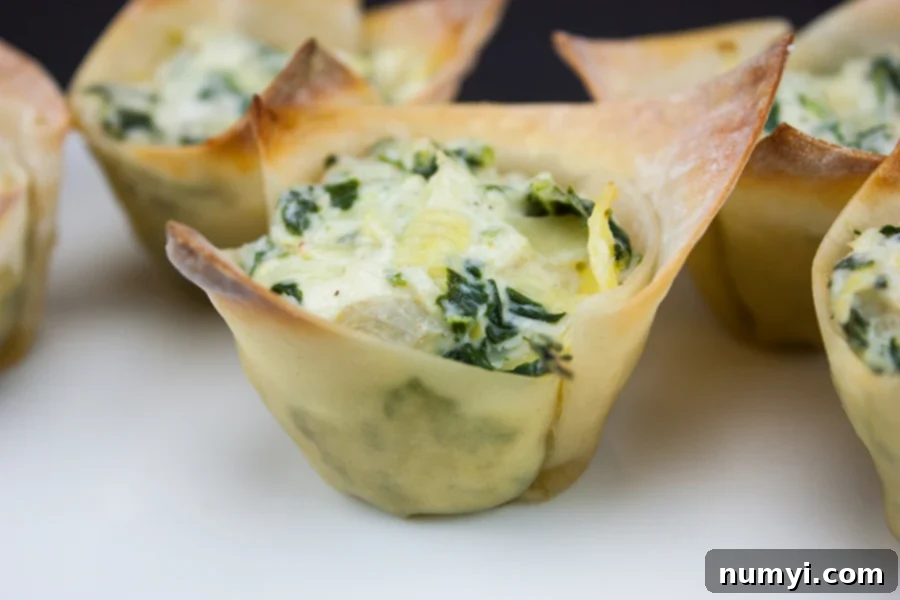 Creamy Spinach Artichoke Bites 6 Fast & Easy Spinach Artichoke Cups beautifully presented on a white platter, ready to serve.