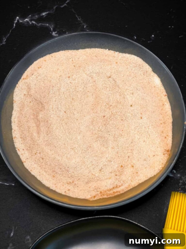 Cinnamon sugar mixture in a shallow dark bowl.