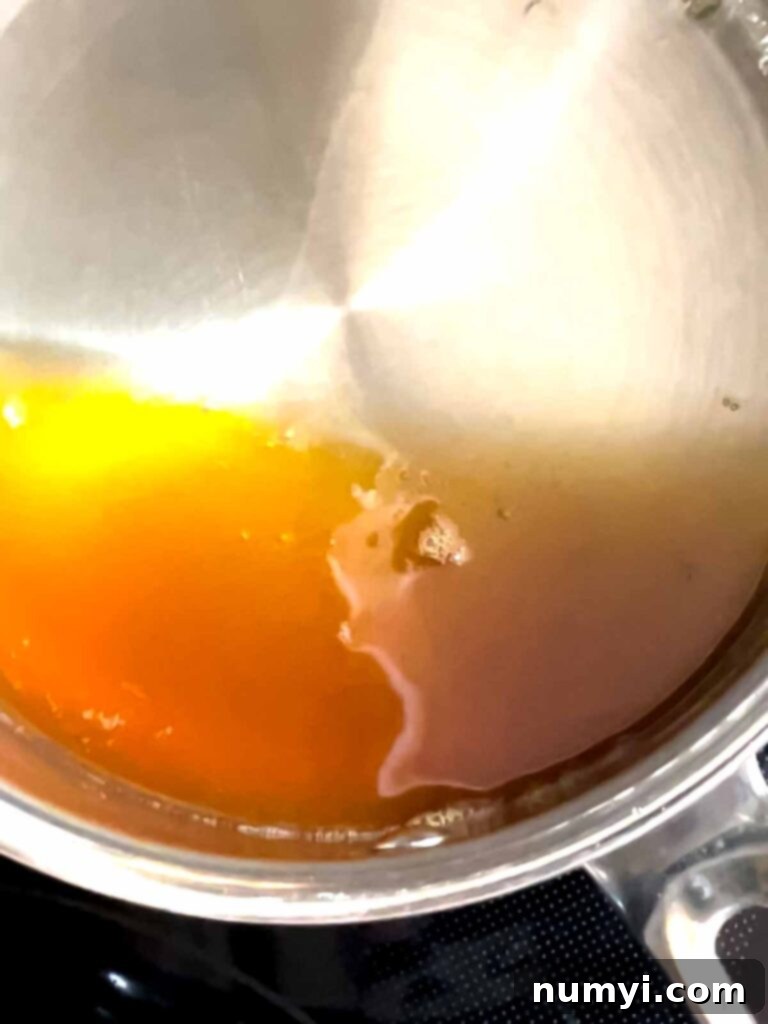 Reduced apple cider in a small sauce pan.