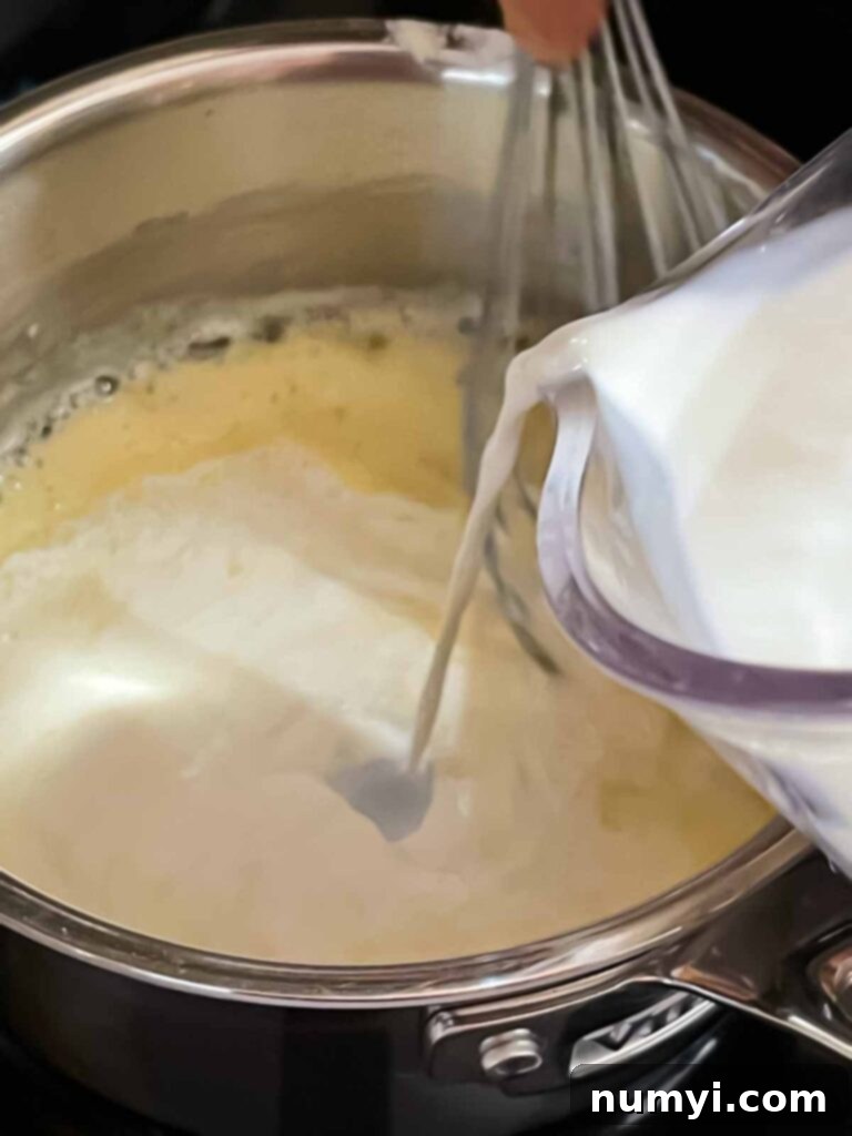 Milk being added slowly to the roux for chicken and wild rice soup.