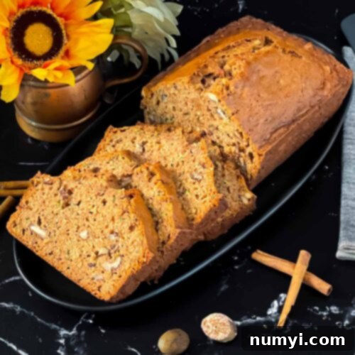 Moist Zucchini Bread 10 Sliced zucchini bread loaf on a dark oval platter on a dark surface.