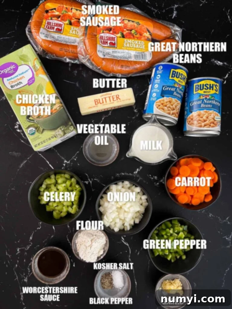 A flat lay of fresh ingredients including smoked sausage, great northern beans, butter, various vegetables, and spices, laid out on a wooden surface for creamy bean soup.