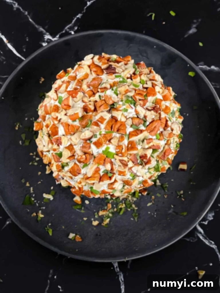 Creamy Garlic Herb Cheese Ball 7 A garlic herb cheese ball just coated with pecans.
