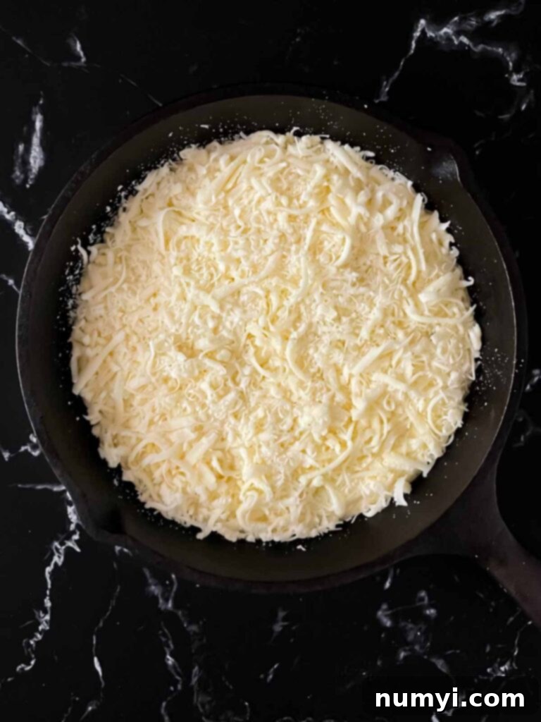 Creamy Baked Ricotta 9 The ricotta dip generously topped with a blend of mozzarella and Romano cheeses in a cast iron skillet, awaiting baking.