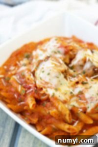 A dish of creamy marinara meatballs and pasta, ready to be served