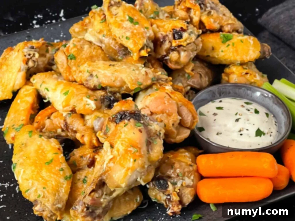 Garlic Parmesan chicken wings on a dark plate.