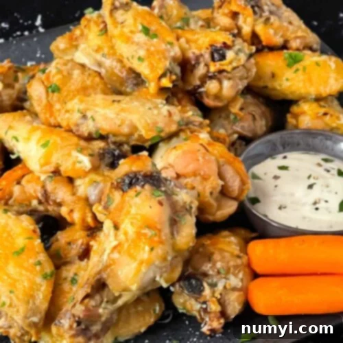 Garlic Parmesan chicken wings on a dark plate.