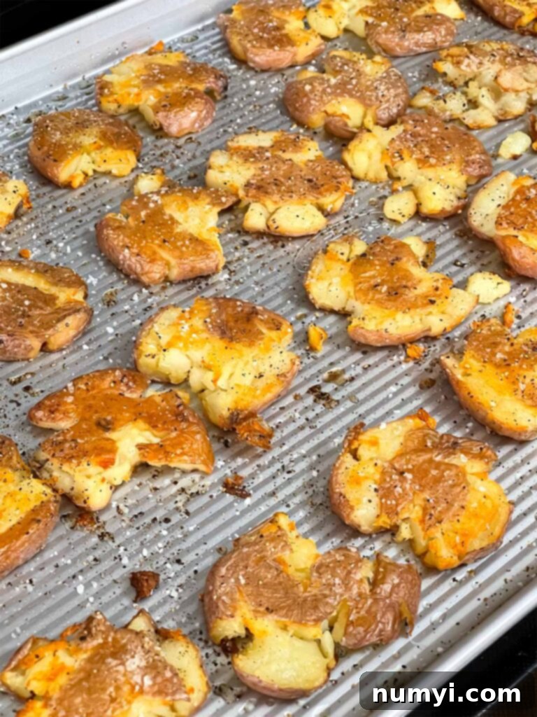 Cooked smashed potatoes on baking sheet pan.