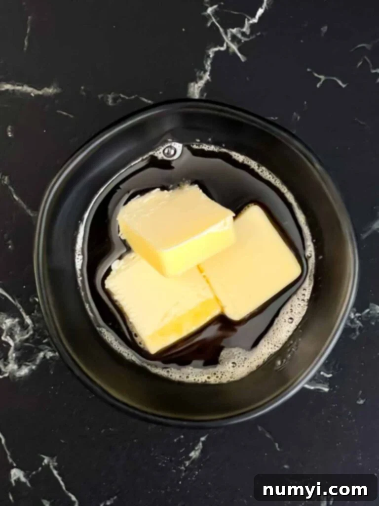 butter and bacon fat in a black ramekin.