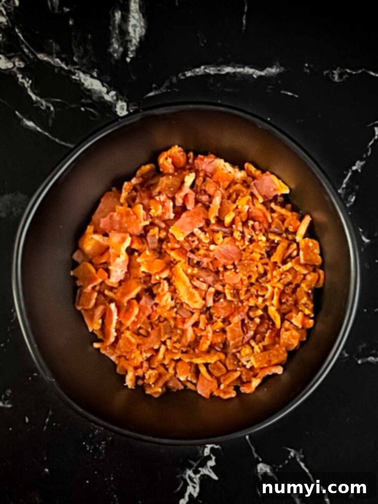 Crumbled bacon in a black dish.