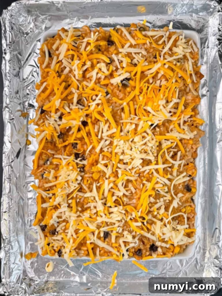 Unbaked chicken enchilada rice casserole in a 9x13 dish, ready for the oven.