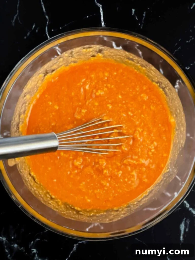 Refried beans and enchilada sauce whisked together until smooth in a glass bowl.