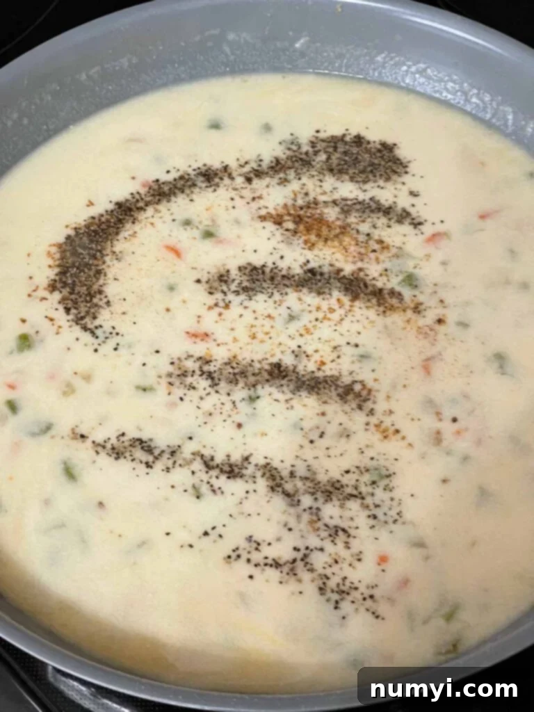 The creamy, rich sauce for Chicken Stuffing Casserole simmering in a skillet, perfectly thickened.