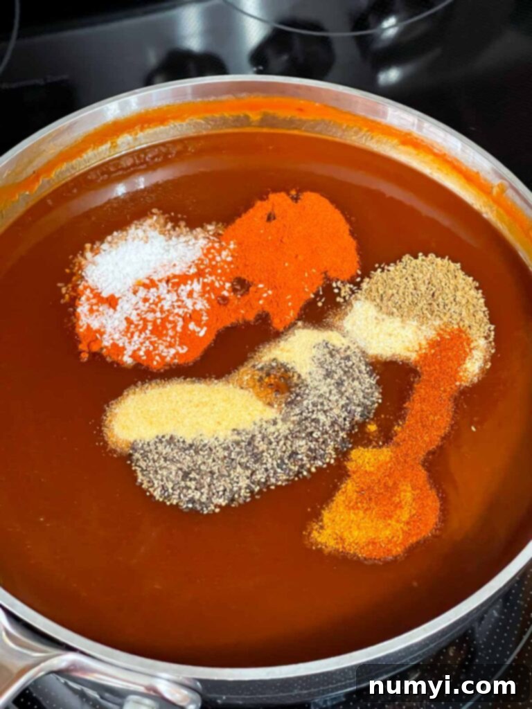 Adding dry spices to the base of Kansas City style barbecue sauce.