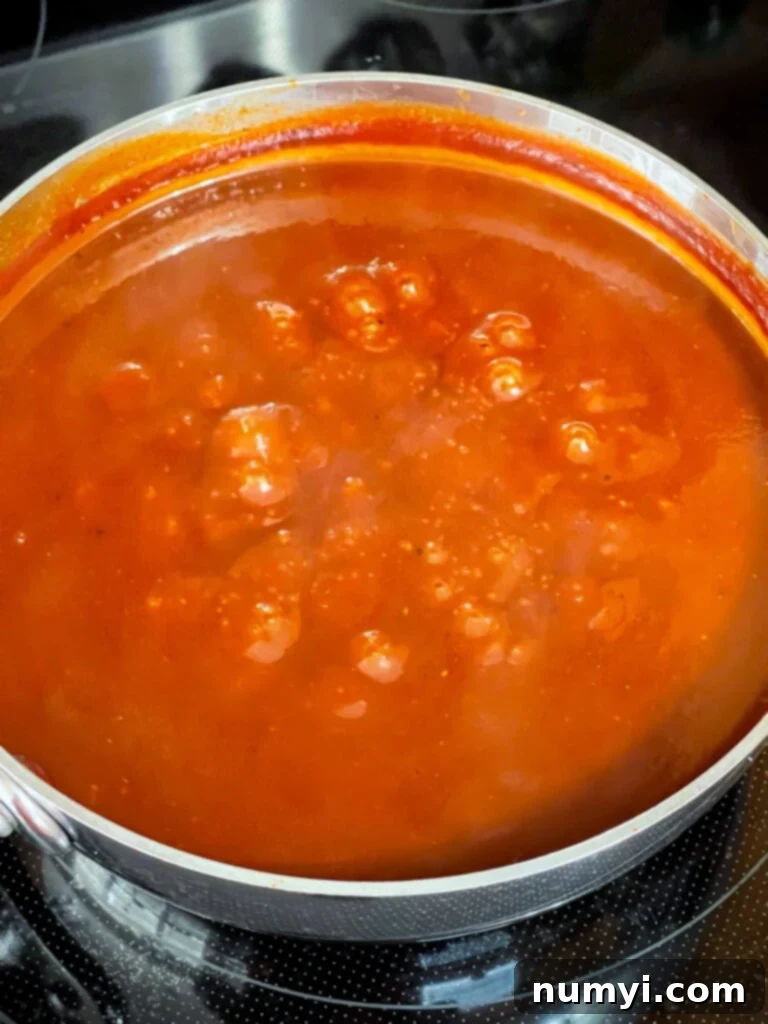 Close-up of Kansas City style barbecue sauce simmering, showing its thick texture.