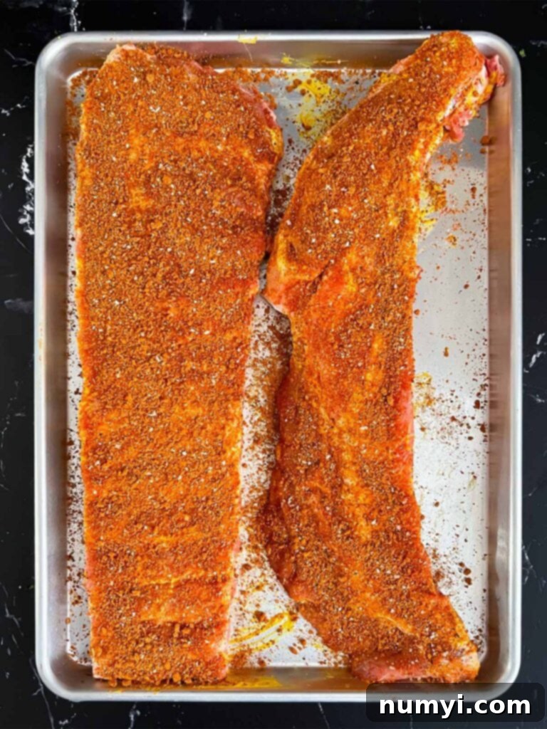 Ribs liberally coated with a flavorful Kansas City style rub, ready for refrigeration.