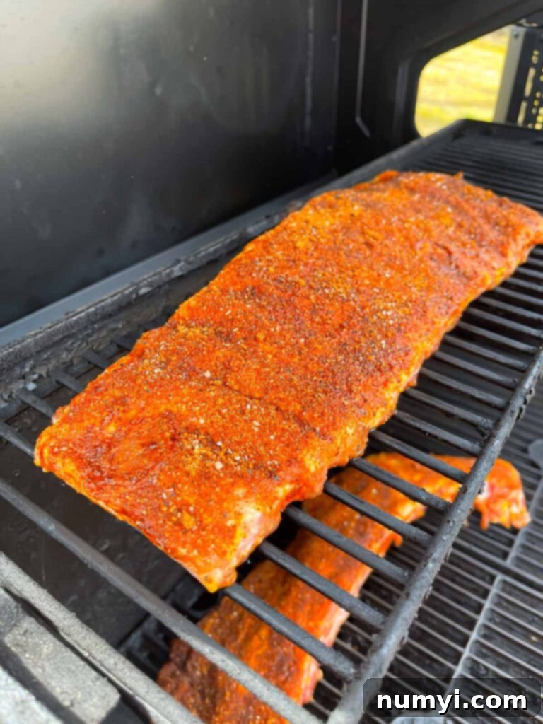 A rack of ribs smoking on the grates, absorbing wood smoke.