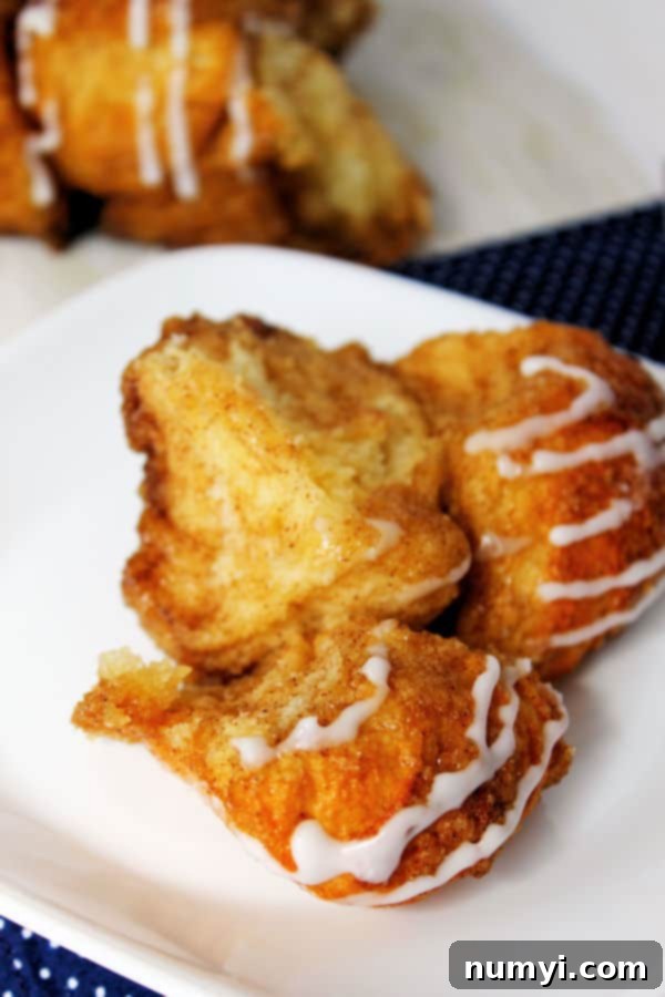 a piece of cinnamon sugar monkey bread pulled apart from the loaf on the plate, showing the gooey interior
