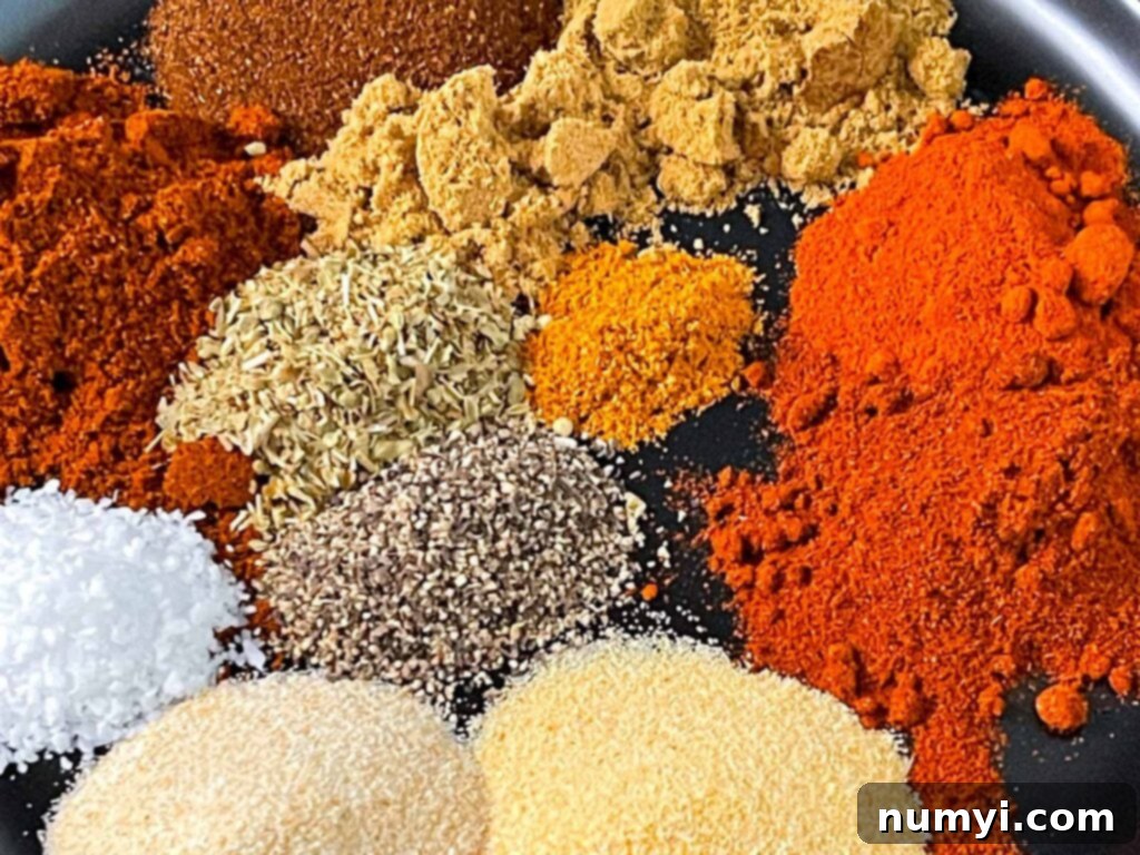 A selection of colorful spices laid out on a black plate, ready to be blended into a homemade Southwest seasoning.