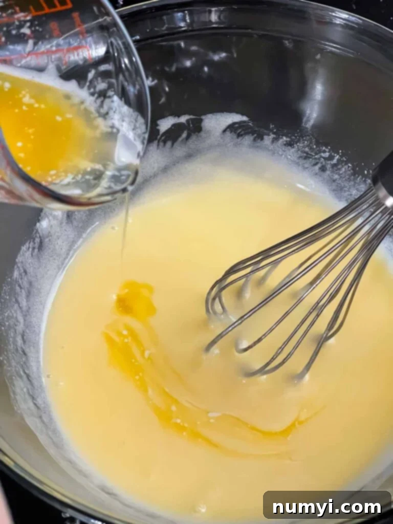 Adding melted butter to an egg mixture.