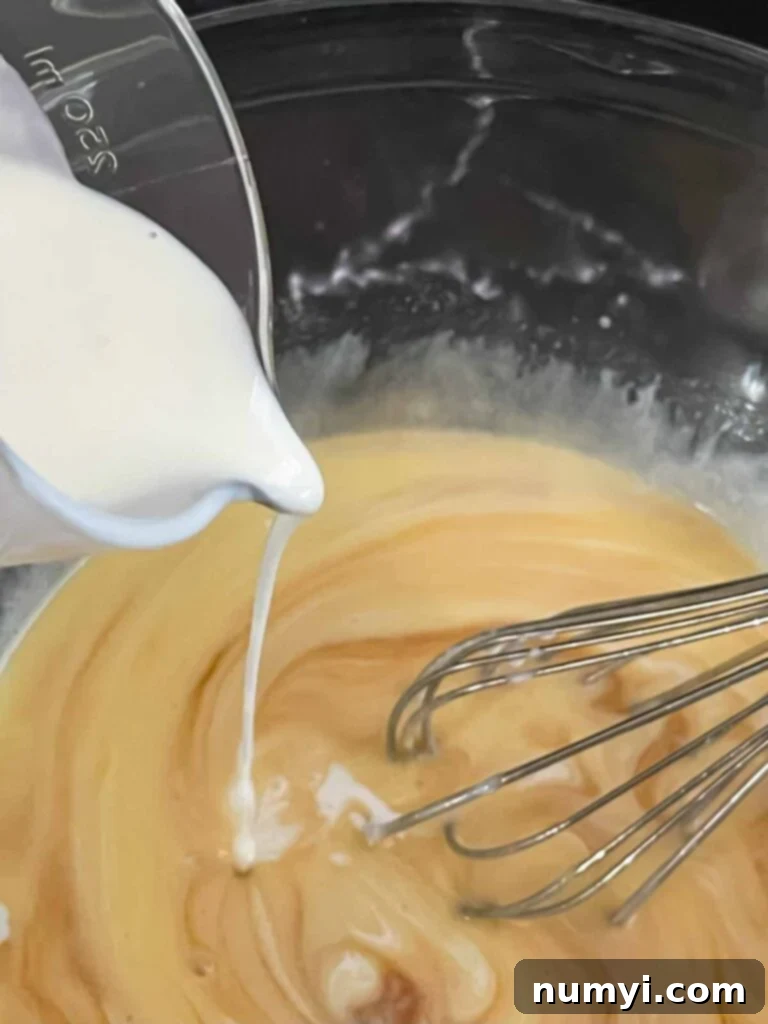Adding buttermilk to an egg mixture.