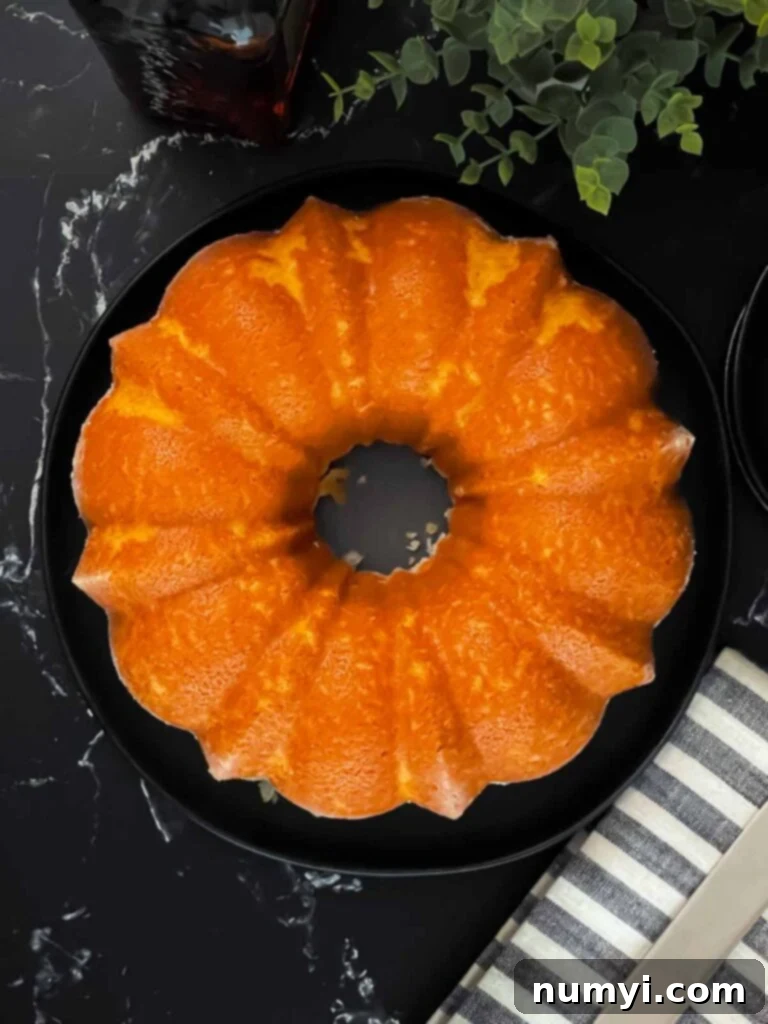 Amaretto pound cake on a black plate, showcasing its golden crust and glaze.