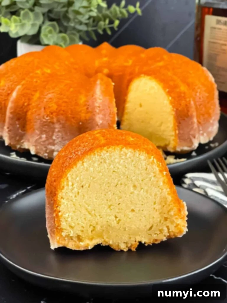 A slice of Amaretto pound cake on a black plate, revealing its moist interior.