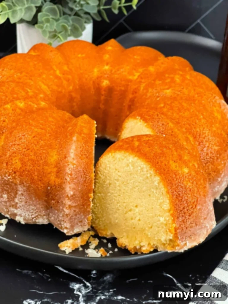 Amaretto pound cake on a black plate, garnished with a few almonds.