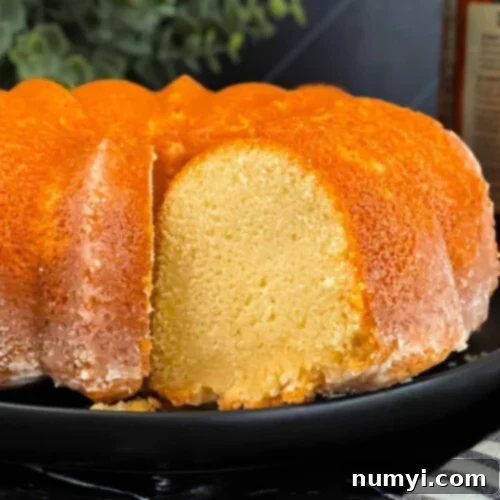 Amaretto pound cake on a black plate, with a perfect slice removed.