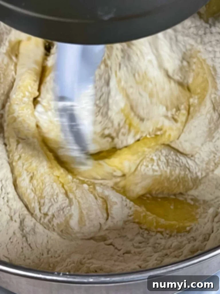 Pound cake batter being made, with dry ingredients and sour cream being alternated.