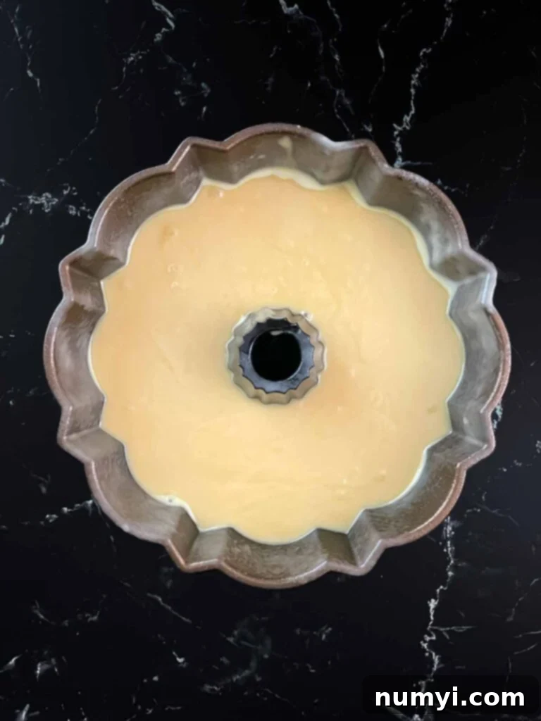 Amaretto pound cake batter evenly poured into a bundt pan, ready for baking.
