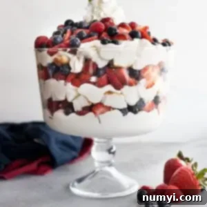 A trifle bowl filled with angel food cake, coconut cheesecake filling, strawberries, blueberries, and raspberries. All in pretty layers.