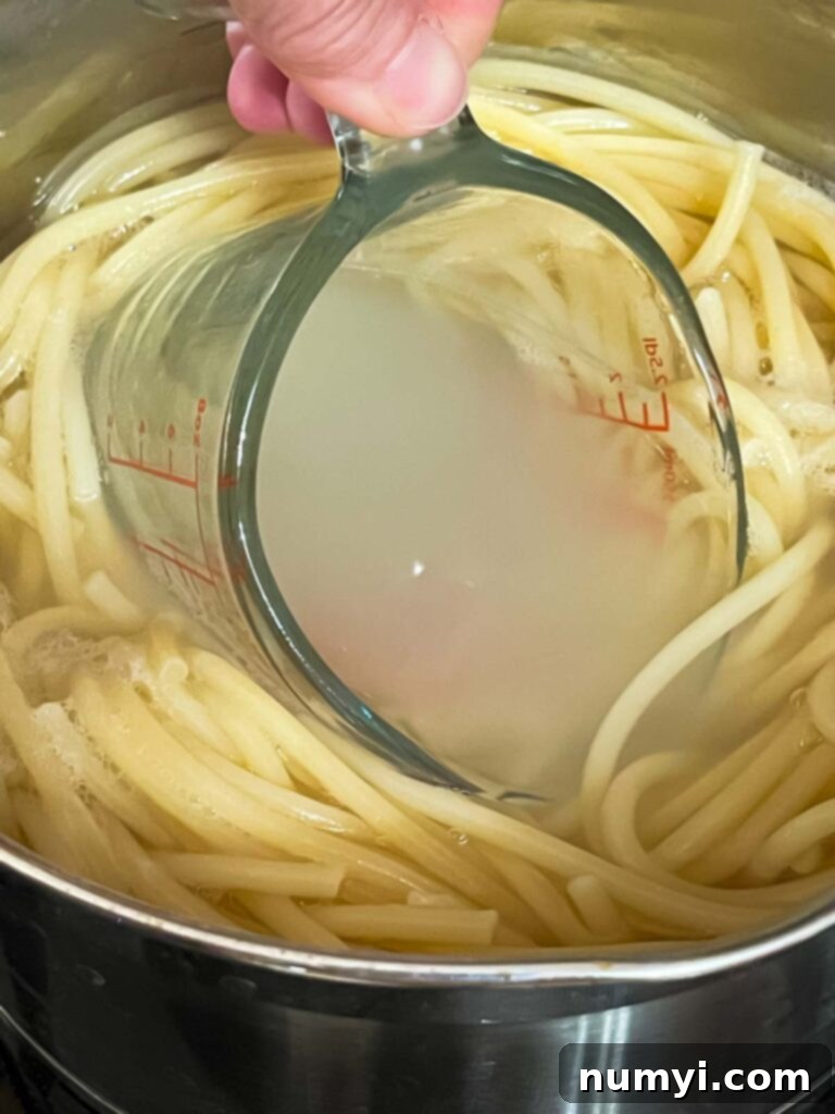 Removing pasta water using a measuring cup.