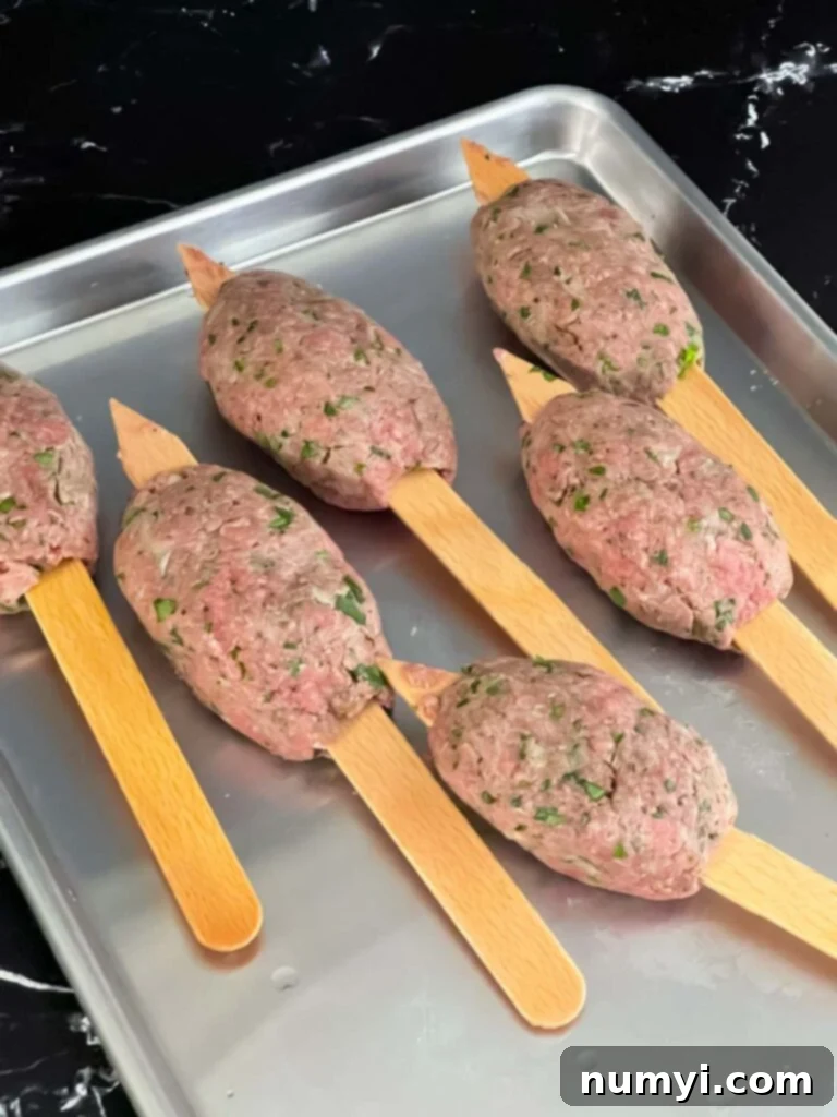 Raw kofte on wooden skewers.