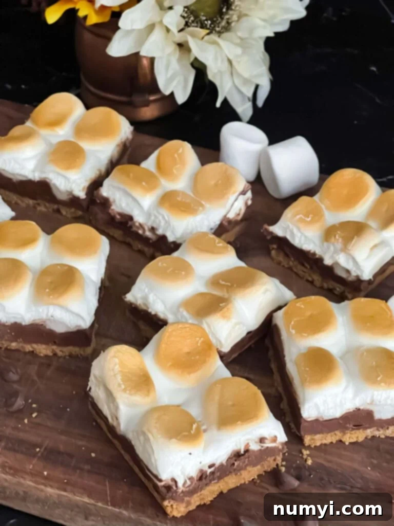 Smores Bars 9 Finished s'mores bars on a wooden cutting board, with perfectly toasted marshmallows.