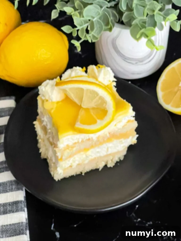 A perfectly portioned serving of Limoncello tiramisu on a dark plate, highlighting its creamy layers.