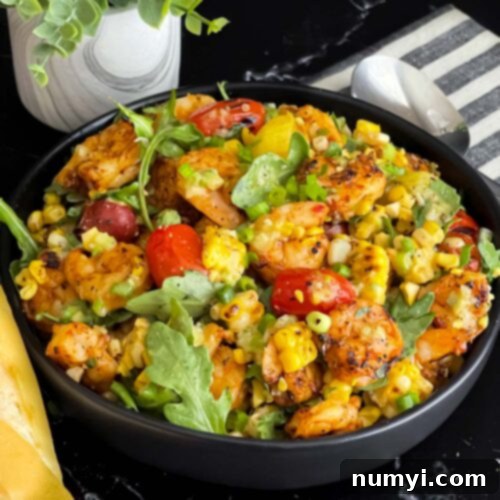 Fresh Grilled Shrimp and Corn Salad 18 Close-up of a serving of Grilled Shrimp and Corn Salad in a dark bowl.