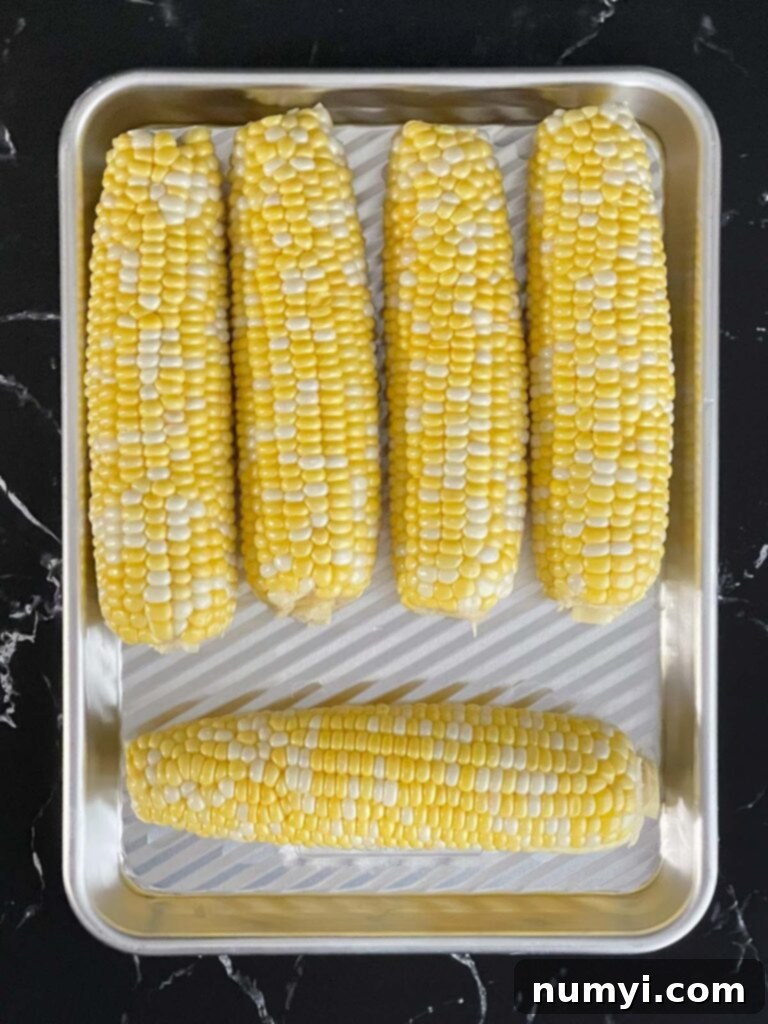 Fresh Grilled Shrimp and Corn Salad 8 Fresh corn on the cob ready for grilling, placed on a small baking sheet.