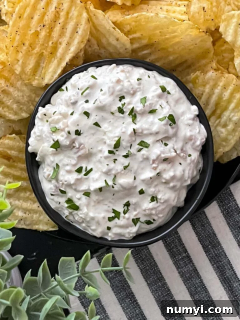 Creamy Clam Dip 6 Clam dip in a dark bowl surrounded by kettle potato chips.