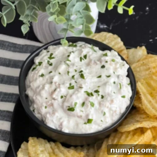 Creamy Clam Dip 7 Clam dip in a dark bowl surrounded by kettle potato chips.