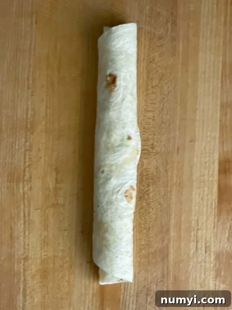Veggie Tortilla Pinwheels 7 Veggie tortilla roll up on a wooden cutting board.
