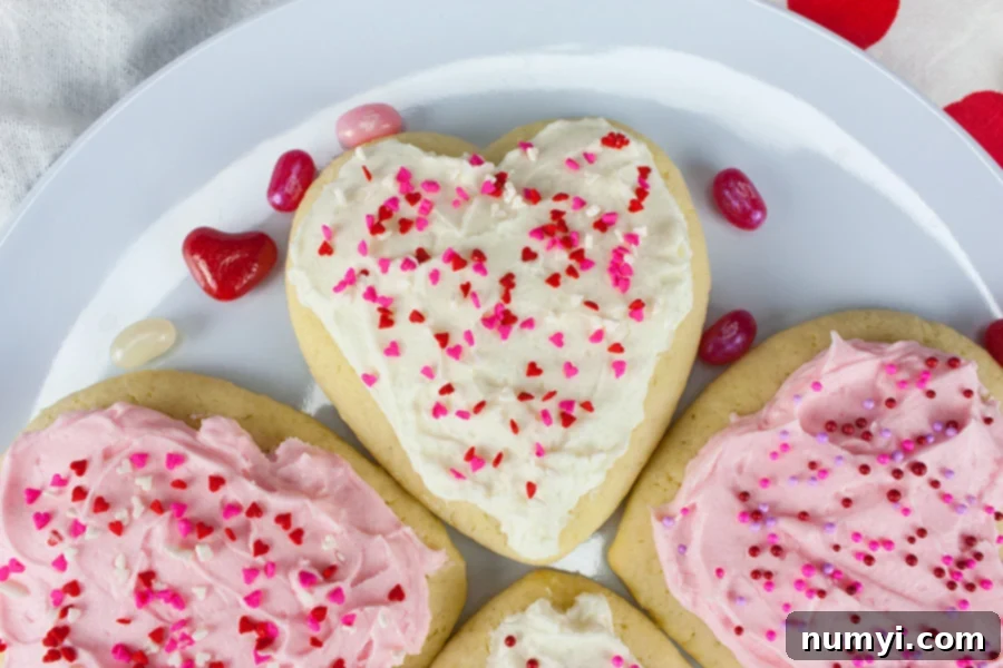 Heart shaped cookies garnished with sprinkles on a plate.