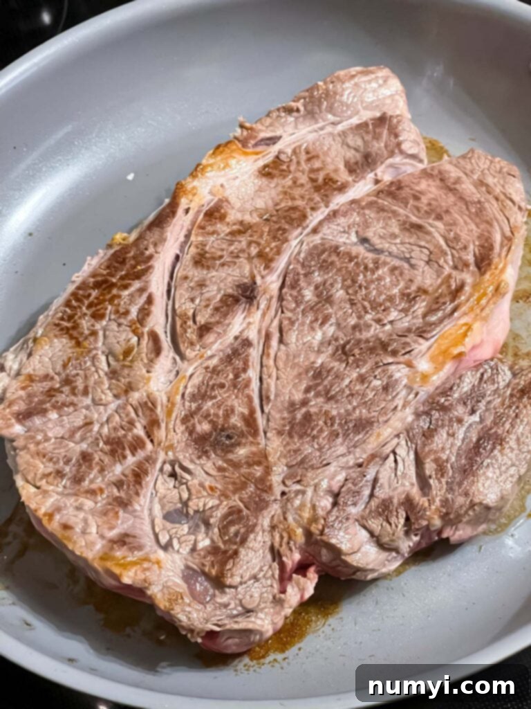 Melt-in-Your-Mouth Slow Cooker Italian Beef Sandwiches 4 Beef chuck roast seared to a golden brown in a skillet before slow cooking.