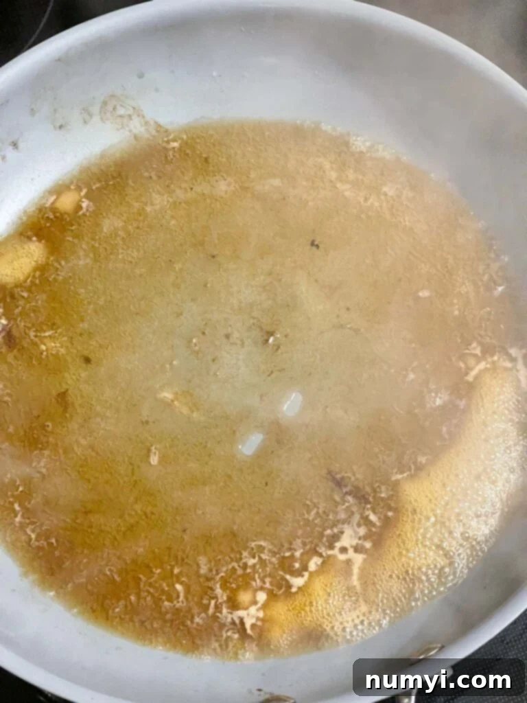 Melt-in-Your-Mouth Slow Cooker Italian Beef Sandwiches 5 Beef broth being used to deglaze the skillet, scraping up the browned bits.
