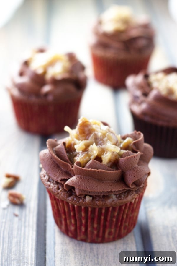 German Chocolate Cupcakes 3 Closer photo of German chocolate cupcakes on a wooden surface, showing the intricate frosting details.