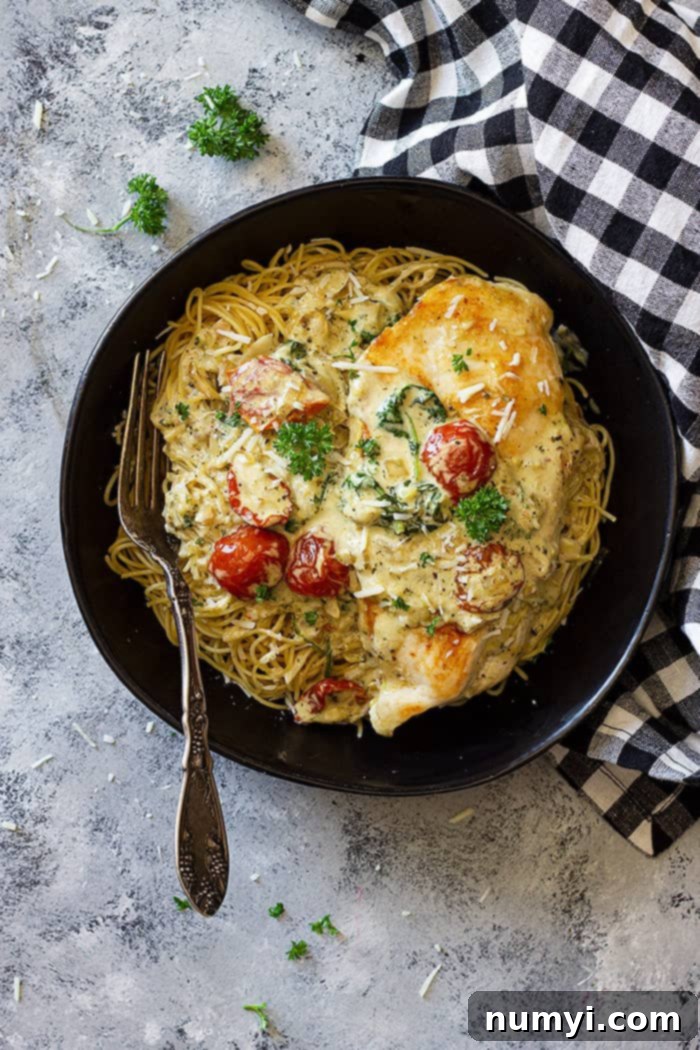 Bowl filled with pasta and topped with creamy tuscan chicken.