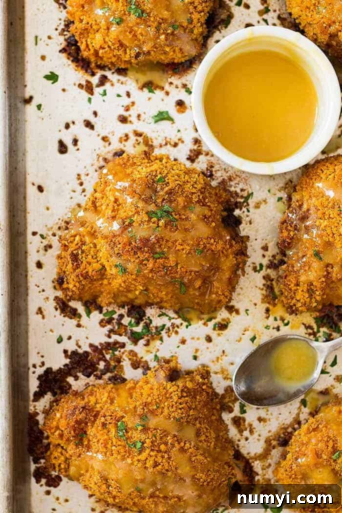 Overhead view of perfectly crispy oven fried chicken thighs, beautifully drizzled with homemade honey mustard sauce.