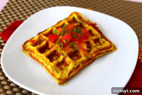 a waffle shaped omelet with tomatoes and garnish on top sitting on a white plate